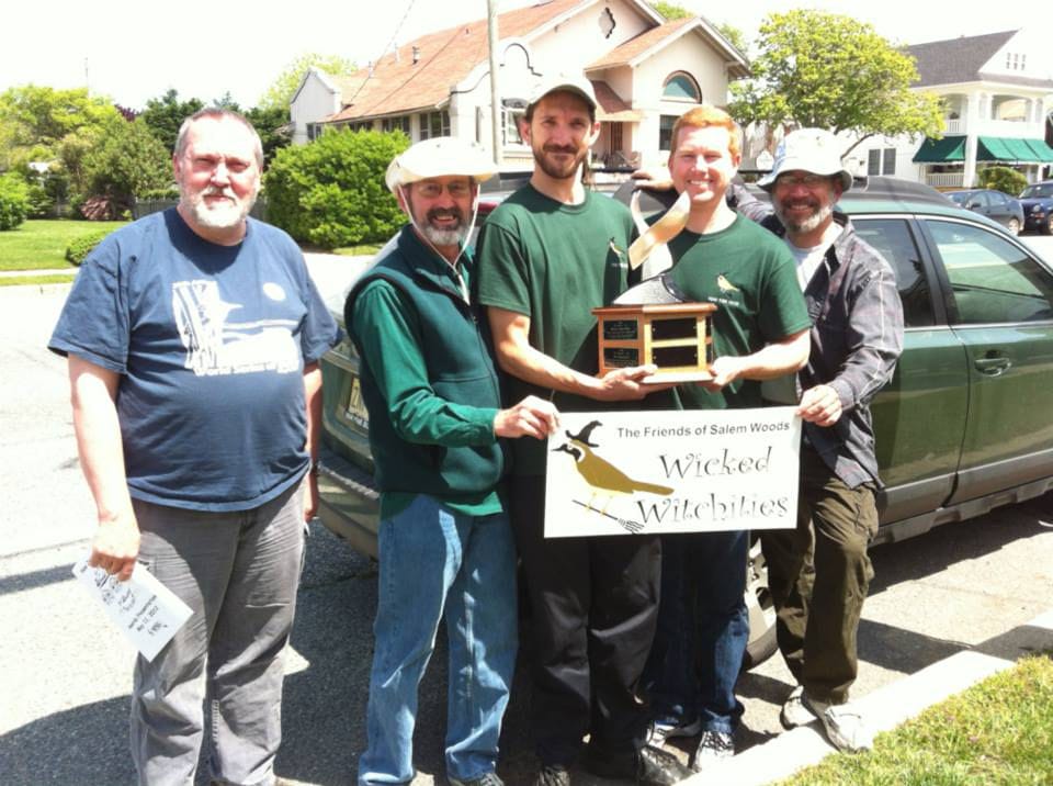 Group holding trophy and sign.